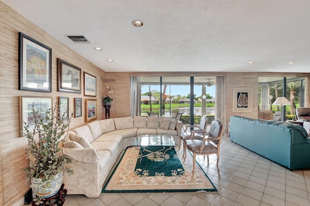 tiled living room with ceiling fan and a textured ceiling