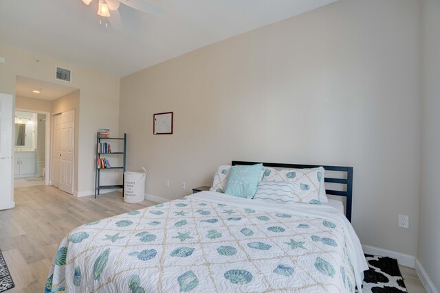 bedroom with ceiling fan, ensuite bathroom, light hardwood / wood-style floors, and a closet