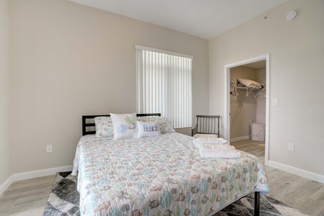 bedroom with light wood-type flooring, a spacious closet, and a closet