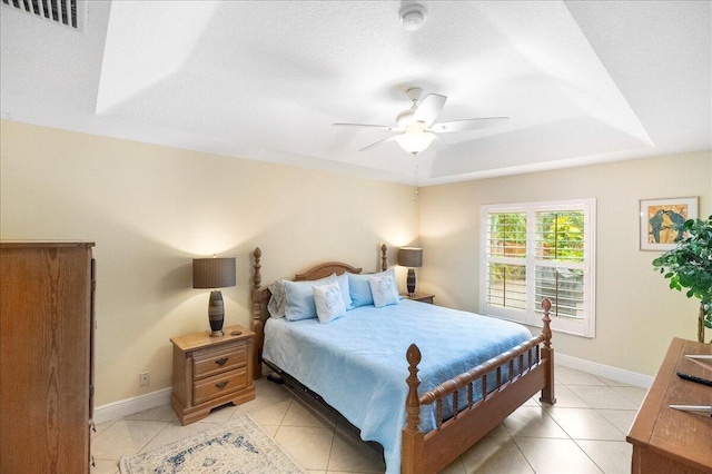 bedroom featuring ceiling fan, light tile patterned floors, and a textured ceiling