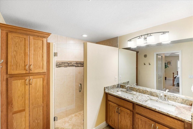 bathroom with vanity, a textured ceiling, and walk in shower