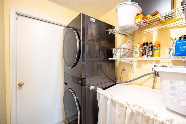 clothes washing area with stacked washer and clothes dryer