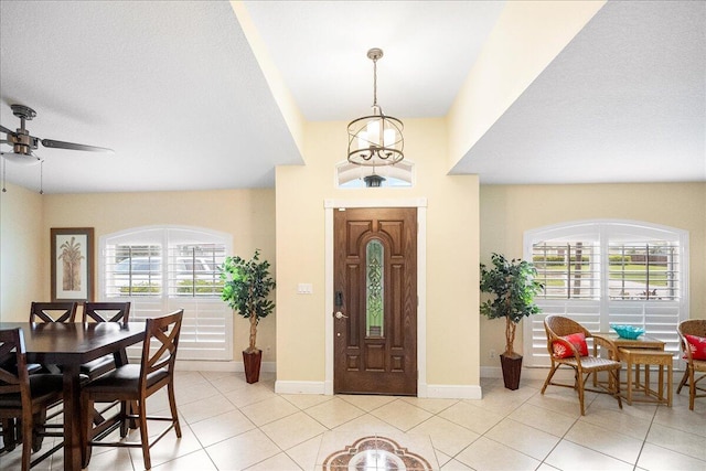 tiled foyer entrance with ceiling fan and a textured ceiling