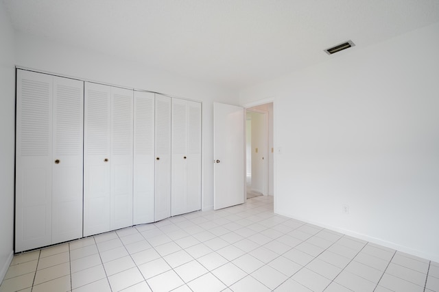 unfurnished bedroom with light tile patterned floors and a closet