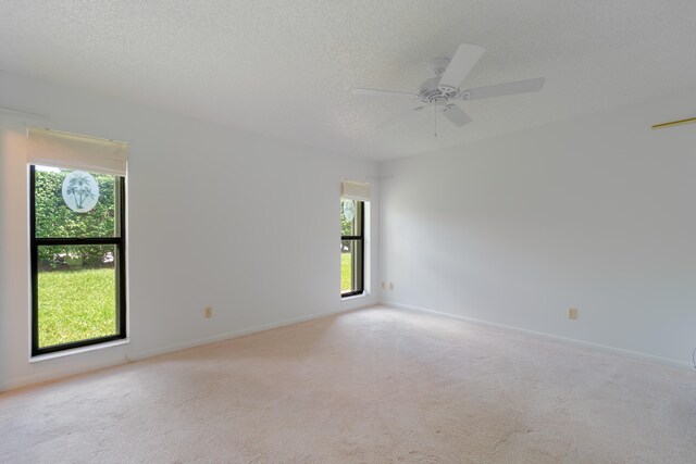 spare room featuring a textured ceiling, carpet flooring, and ceiling fan