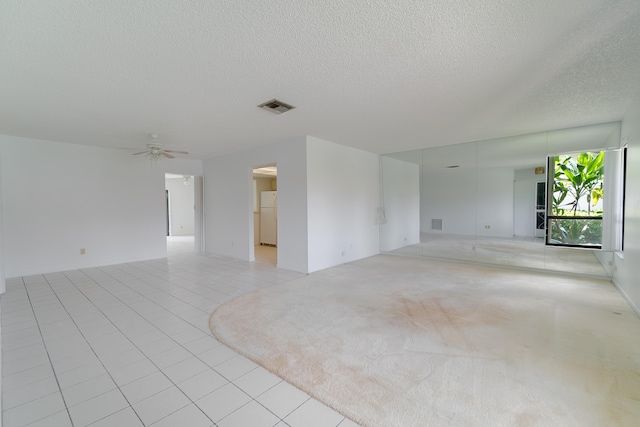 spare room featuring ceiling fan, a textured ceiling, and light tile patterned floors