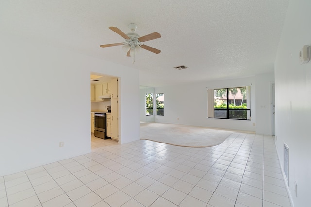 spare room with ceiling fan, light tile patterned floors, and a textured ceiling