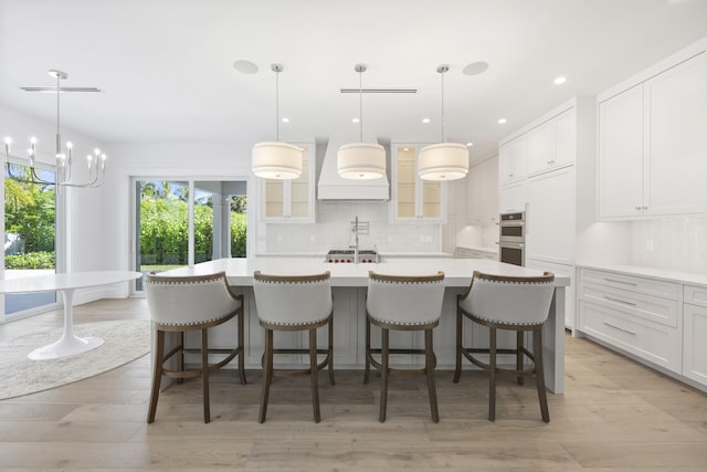 kitchen with a kitchen bar, hanging light fixtures, and a spacious island