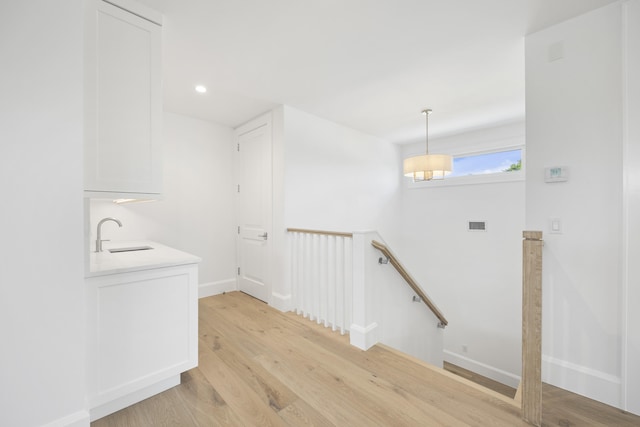 hall featuring light wood-type flooring and sink