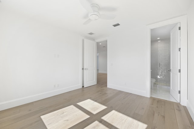 unfurnished bedroom with ensuite bath, ceiling fan, and light hardwood / wood-style floors