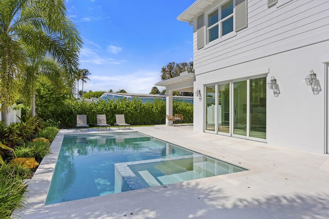 view of swimming pool featuring a patio and an in ground hot tub