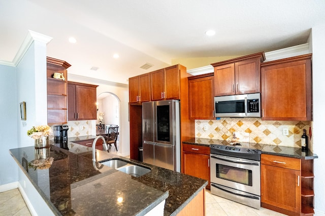 kitchen with decorative backsplash, appliances with stainless steel finishes, sink, and vaulted ceiling