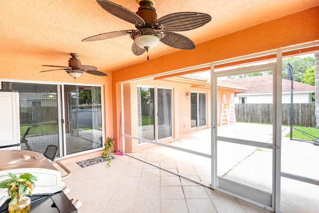 unfurnished sunroom featuring ceiling fan