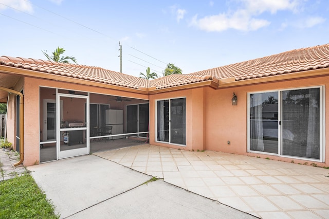 back of house with ceiling fan, a patio area, and a sunroom