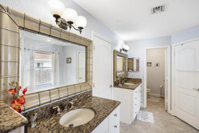 bathroom featuring toilet, tile patterned floors, and vanity