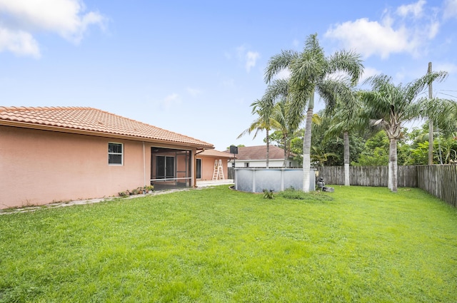 view of yard featuring a fenced in pool and a sunroom