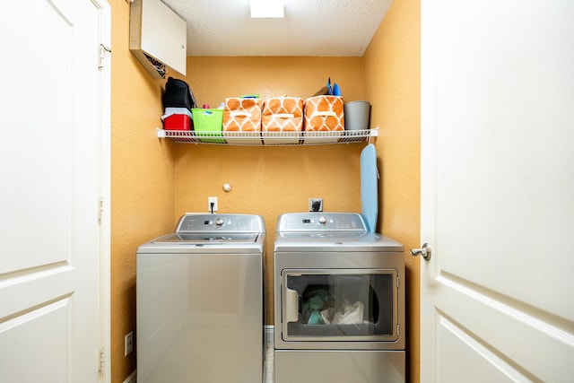 laundry room with a textured ceiling and independent washer and dryer