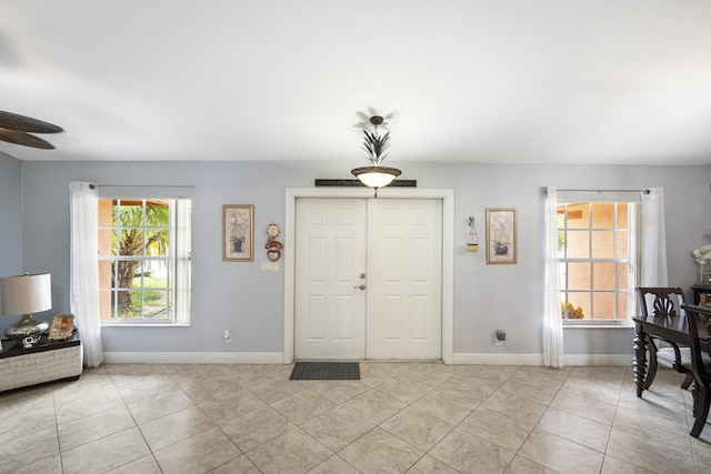 entryway with ceiling fan and light tile patterned floors