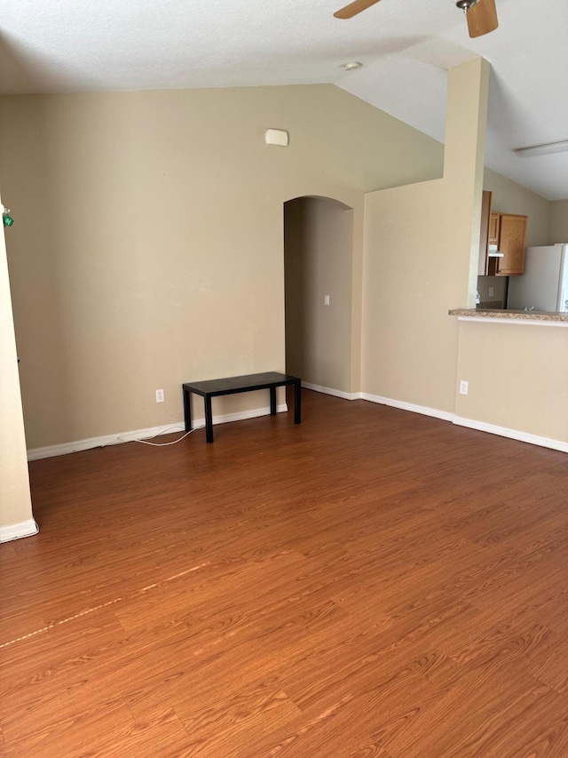 unfurnished living room with ceiling fan, light wood-type flooring, and lofted ceiling