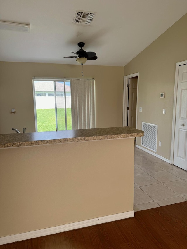 kitchen featuring hardwood / wood-style flooring, ceiling fan, and vaulted ceiling