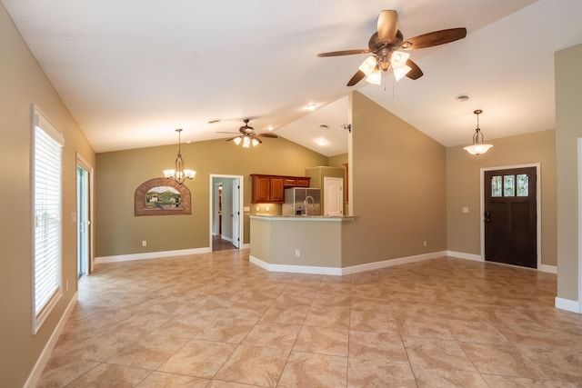 unfurnished living room with visible vents, vaulted ceiling, baseboards, and ceiling fan with notable chandelier