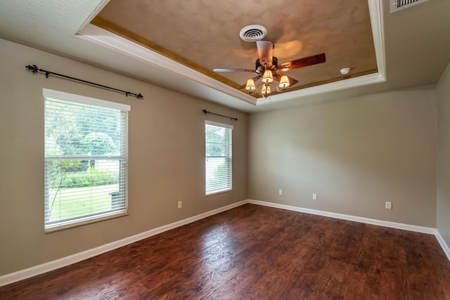 unfurnished room featuring a raised ceiling, visible vents, baseboards, and wood finished floors