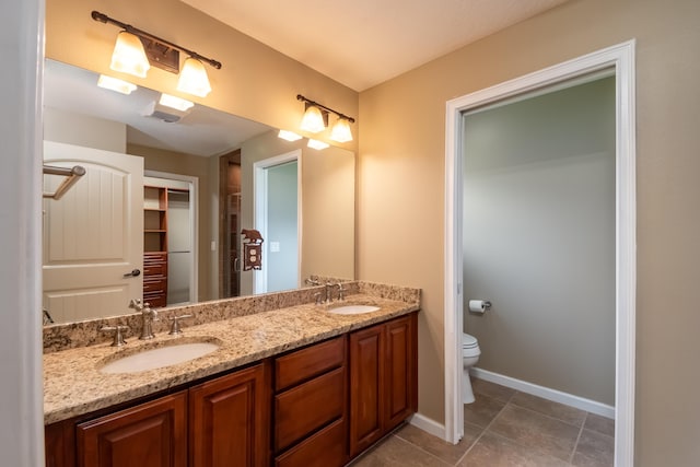 bathroom with tile patterned floors, a sink, toilet, and double vanity