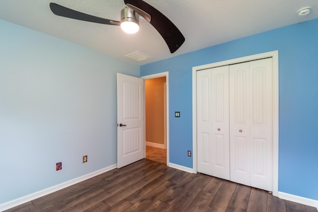 unfurnished bedroom with visible vents, baseboards, dark wood finished floors, ceiling fan, and a closet