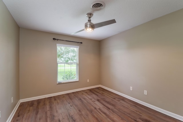 empty room featuring baseboards, visible vents, ceiling fan, wood finished floors, and a textured ceiling