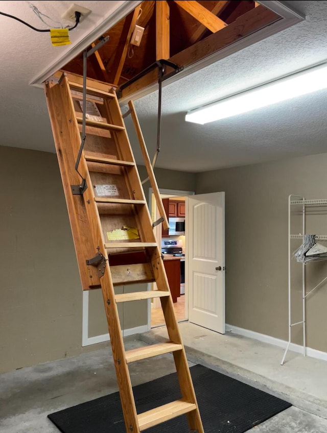 basement with a textured ceiling and baseboards