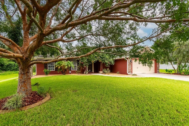 ranch-style house featuring a front yard, concrete driveway, and an attached garage