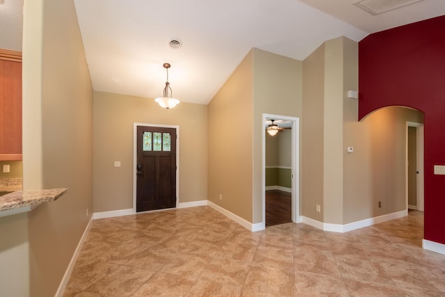 foyer entrance with arched walkways, ceiling fan, visible vents, and baseboards