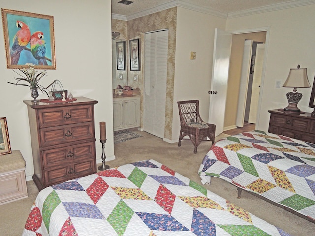 bedroom with light colored carpet, ensuite bath, a closet, and crown molding