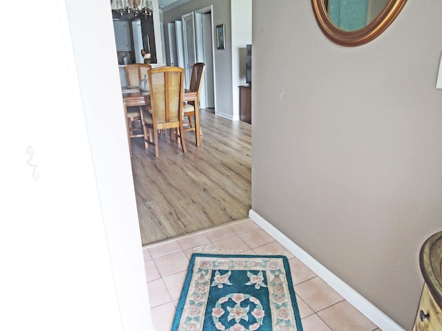 hall with a notable chandelier and light hardwood / wood-style floors