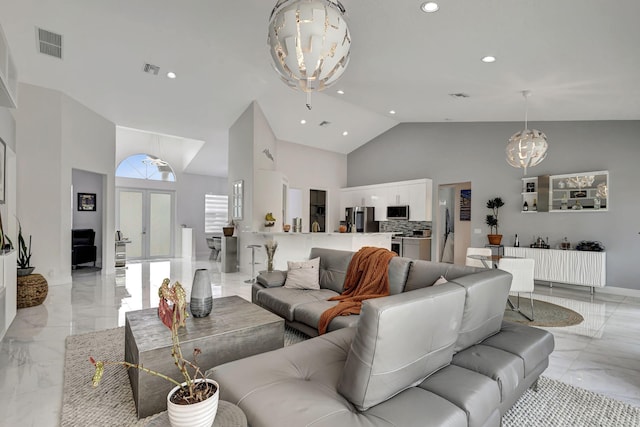 living room with a notable chandelier, light tile patterned floors, french doors, and high vaulted ceiling