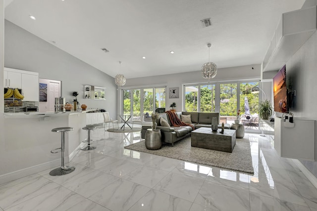 living room featuring light tile patterned floors, high vaulted ceiling, and a chandelier