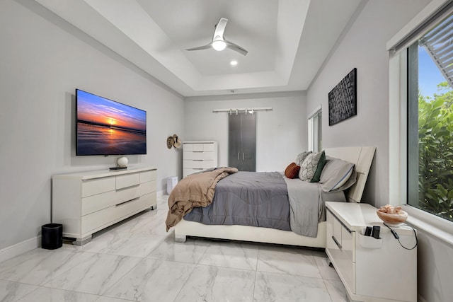 bedroom with ceiling fan, light tile patterned flooring, and a raised ceiling