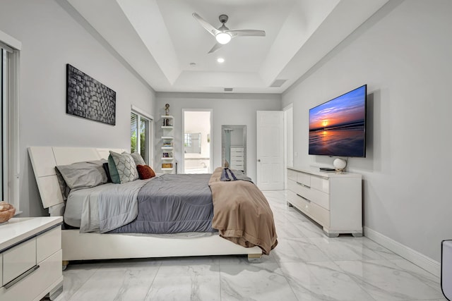 bedroom with ceiling fan, light tile patterned flooring, and a tray ceiling