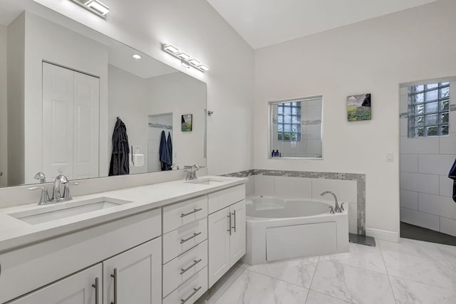 bathroom featuring a wealth of natural light, double vanity, a bathing tub, and tile patterned flooring