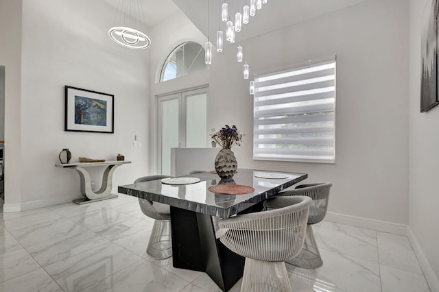 tiled dining space with a towering ceiling