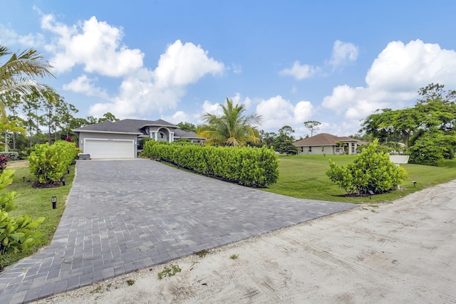 single story home featuring a front lawn and a garage