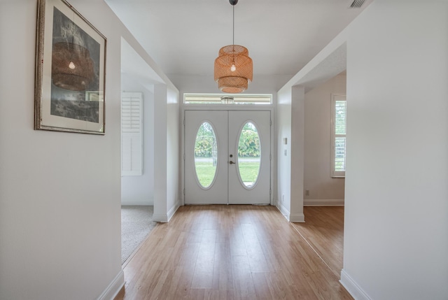 foyer entrance with light hardwood / wood-style flooring and french doors