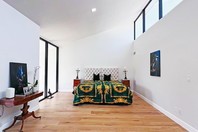 bedroom featuring light wood finished floors and baseboards