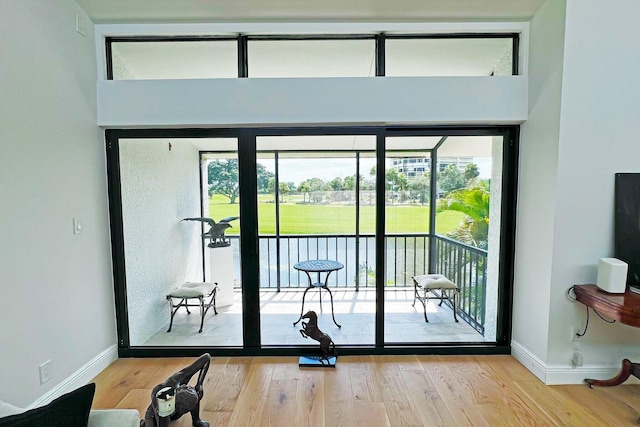 doorway to outside with baseboards and wood finished floors