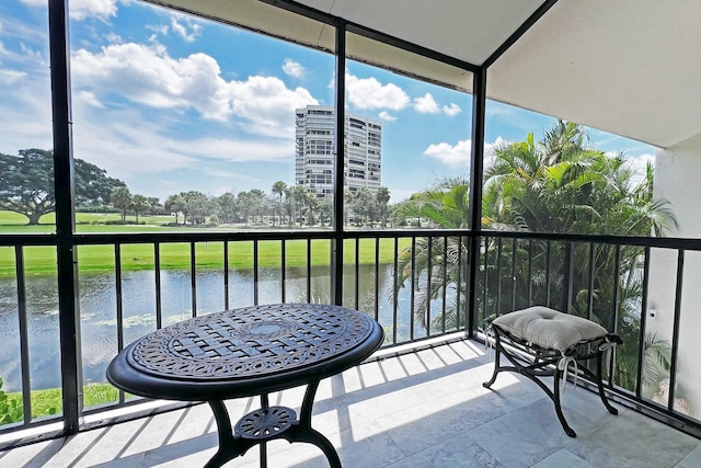 balcony featuring a water view and a sunroom