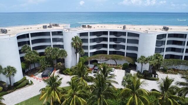 view of building exterior featuring a water view and a beach view