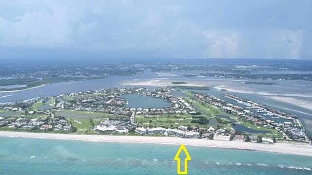 birds eye view of property with a water view and a view of the beach