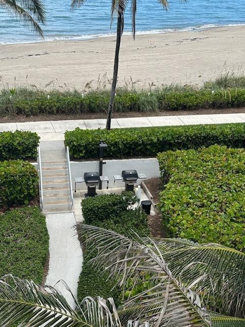 view of yard with a beach view and a water view