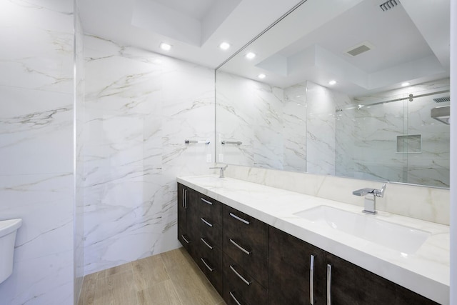 bathroom featuring vanity, toilet, and a shower with door