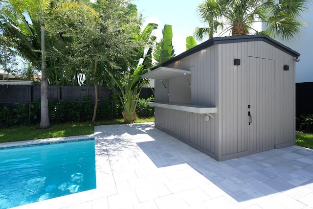 view of pool featuring a patio area and a shed